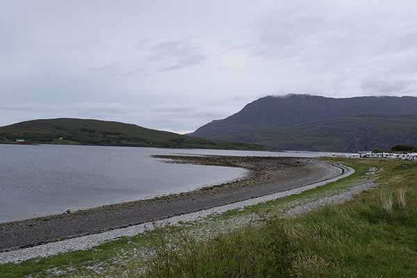 scenic, curved pebble shoreline of Ardmair Beach, located near Ullapool i
